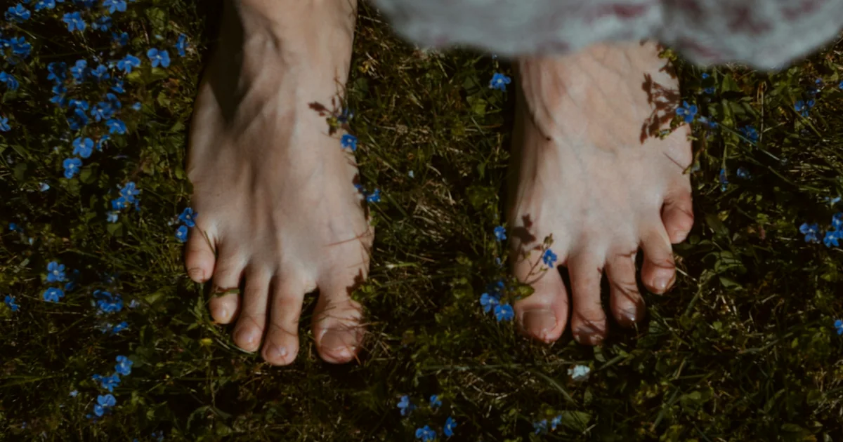 Pieds nus posés sur l'herbe, dans la verdure