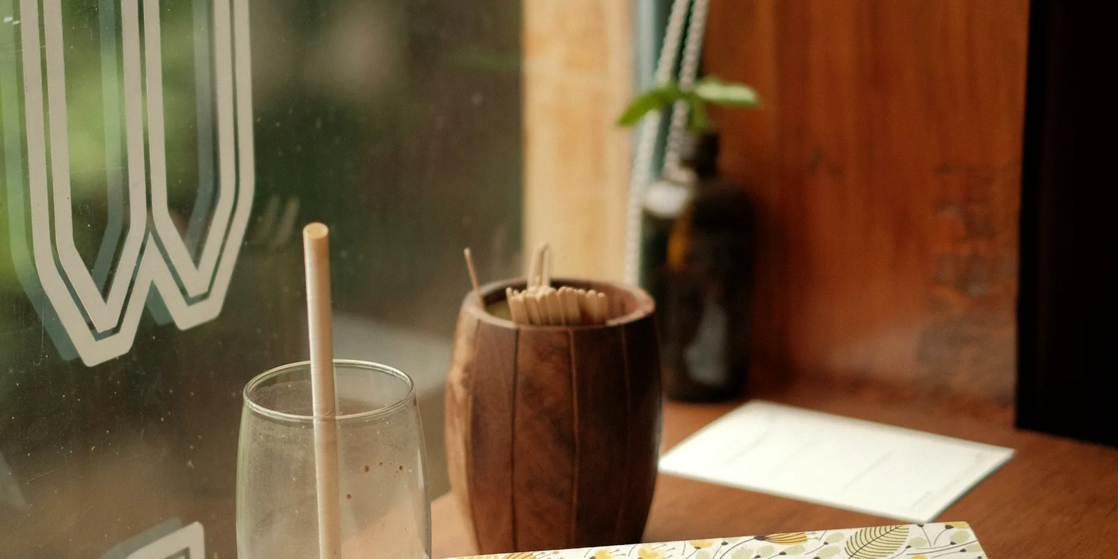 Un carnet ouvert sur une table en bois, près d'une fenêtre